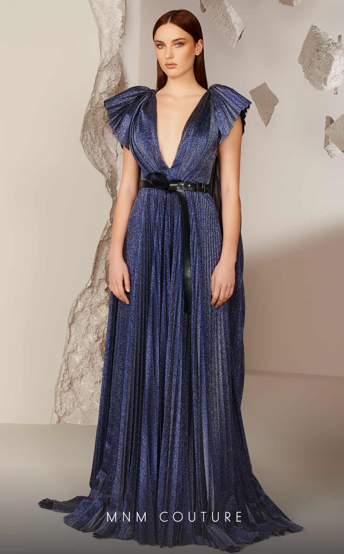 MNM Couture E0018 boasts a trending metallic fabric with a deep V neckline and low back, belted waist with butterfly sleeve details with a beautiful cape falling to the floor.